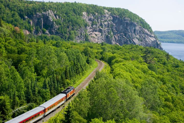 a large long train on a train track with a mountain in the background